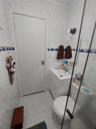a white bathroom with a toilet and a shower at Apto Centro Bertioga (800 metros da praia) in Bertioga
