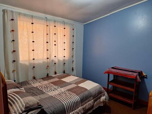 Schlafzimmer mit blauen Wänden und einem Bett mit Fenster in der Unterkunft Cozy home with garden overlooking the Vilcanota river in Pisac