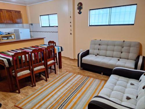ein Wohnzimmer mit einem Sofa und einer Küche in der Unterkunft Cozy home with garden overlooking the Vilcanota river in Pisac