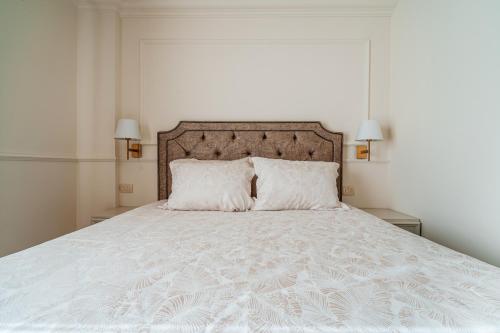 a bedroom with a white bed with two pillows at SunSet Boutique Hotel in Sveti Stefan