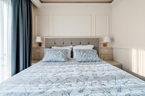 a bedroom with a large bed with a blue bedspread and pillows at SunSet Boutique Hotel in Sveti Stefan