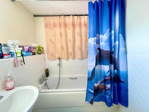 a bathroom with a tub and a shower curtain at Spacious room with study table in Hatfield