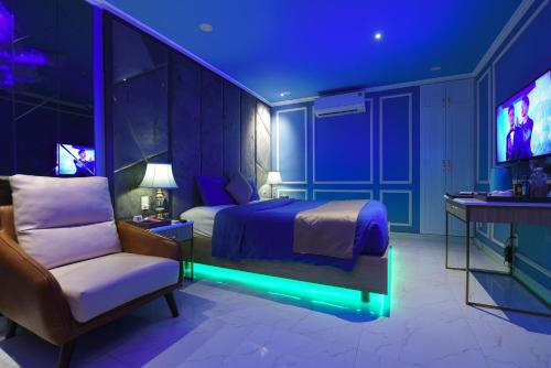 sypialnia z łóżkiem, krzesłem i telewizorem w obiekcie Chiic House 1 - Khách sạn tình yêu w mieście Da Nang