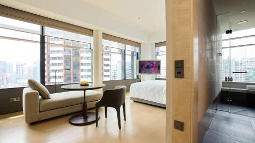 a bedroom with a bed and a table and a chair at COMO Metropolitan Singapore in Singapore