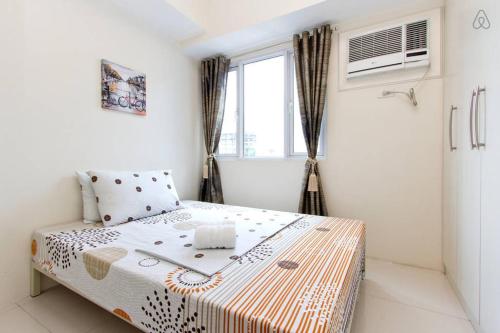 ein Schlafzimmer mit einem Bett und einem Fenster in der Unterkunft Condo Studio Luxe in Princeton Residences in Manila