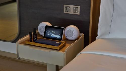 a side table with a bed and a tablet on it at COMO Metropolitan Singapore in Singapore