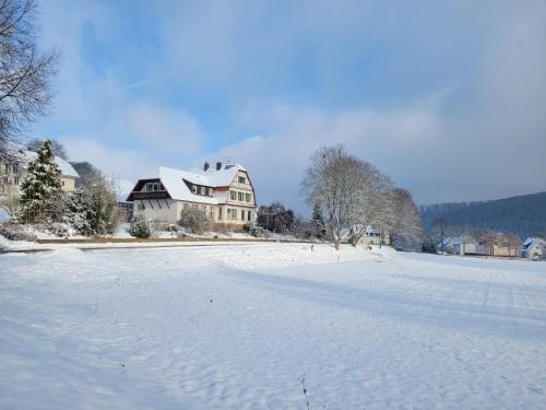 a snow covered field with a house in the background at Alte Dorfschule Kohlgrund in Bad Arolsen
