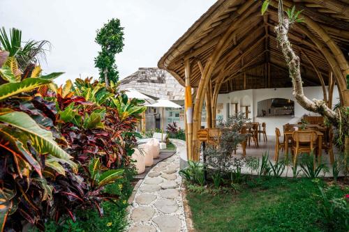a garden with a pavilion with a table and chairs at Shanti Boutique Retreat in Tanah Lot