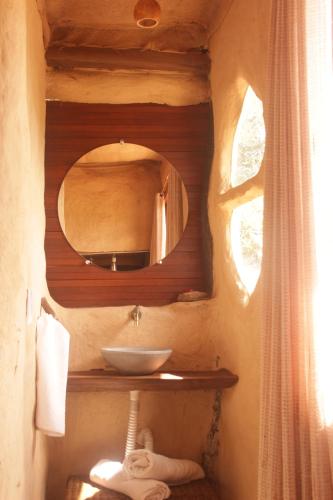ein Bad mit einem Waschbecken und einem Spiegel in der Unterkunft Chalé Pau-Terra in Sao Jorge
