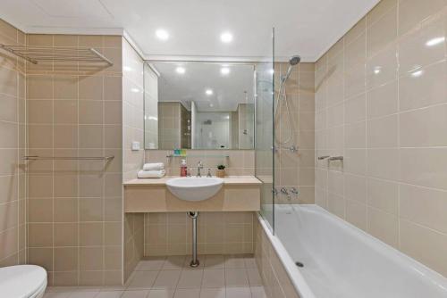 a bathroom with a sink and a tub and a toilet at Comfy Studio Next to Chatswood Station in Sydney