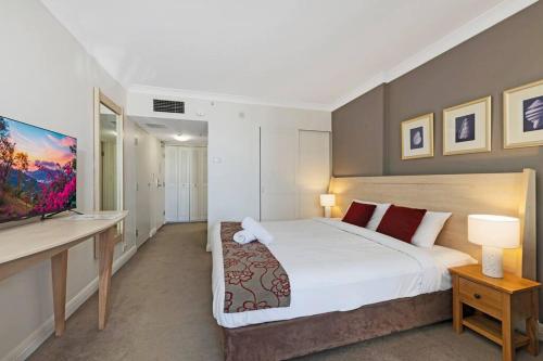 a bedroom with a large bed and a television at Comfy Studio Next to Chatswood Station in Sydney