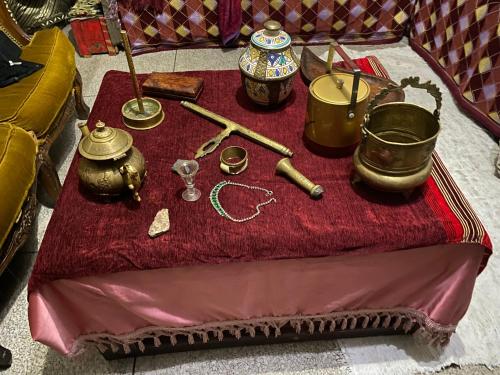 a table with various items on a red table cloth at La Casa Del Colonel in Marrakesh