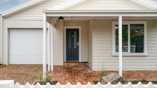 a house with a blue door and a garage at Rock Cottage in Trentham