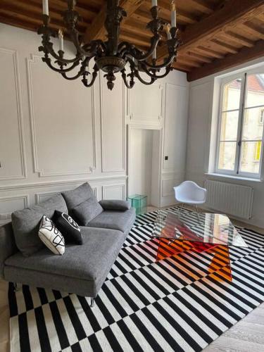 a living room with a couch and a chandelier at Le Grand Cerf By La Chambre à Côté in Metz