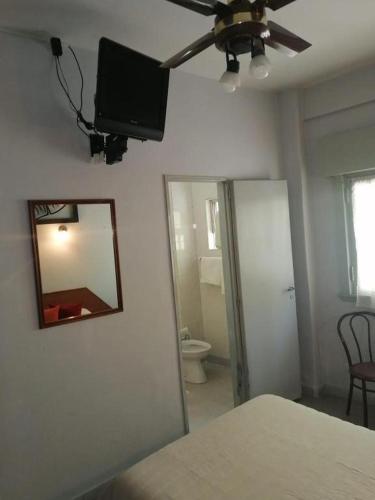a room with a mirror and a tv on the wall at Suite Confortable en Palermo Omega in Buenos Aires