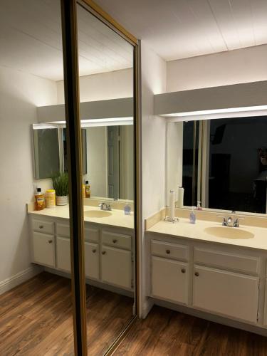 a bathroom with two sinks and two mirrors at Private Room with Private Bath in Rialto