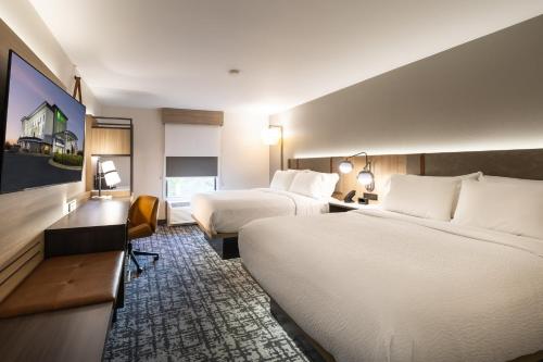 ein Hotelzimmer mit 2 Betten und einem Schreibtisch in der Unterkunft Holiday Inn Anderson, an IHG Hotel in Anderson