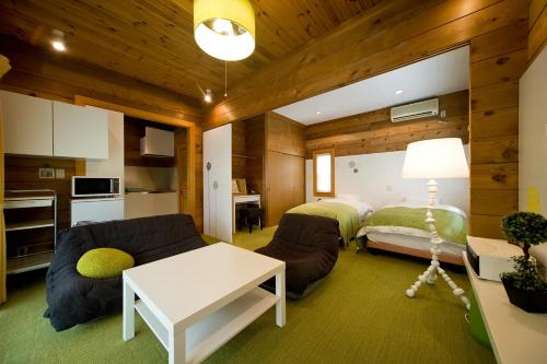 a bedroom with a bed and a couch and a table at Holiday House Green Garden in Gujo