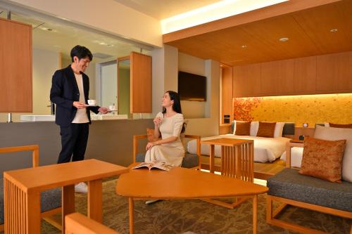 a man and a woman standing in a hotel room at KAYA Kyoto Nijo Castle, BW Signature Collection by Best Western in Kyoto