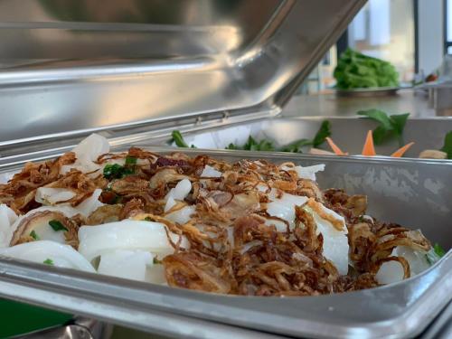 a metal dish of food in a buffet at Bờ Biển Vàng Resort in Ke Ga