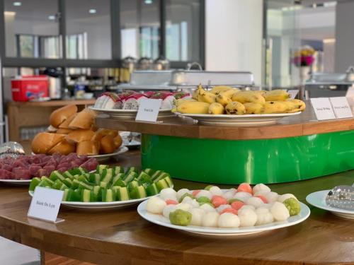 a buffet with plates of fruit and vegetables on a counter at Bờ Biển Vàng Resort in Ke Ga