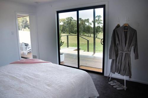 - une chambre avec un lit et une porte coulissante en verre dans l'établissement kentonviewsestate, à Gumeracha