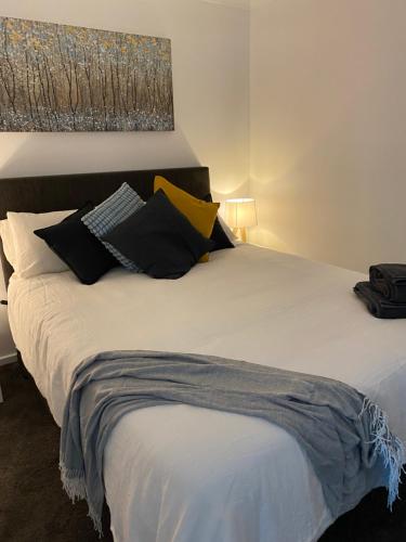 a bedroom with a bed with black and yellow pillows at kentonviewsestate in Gumeracha