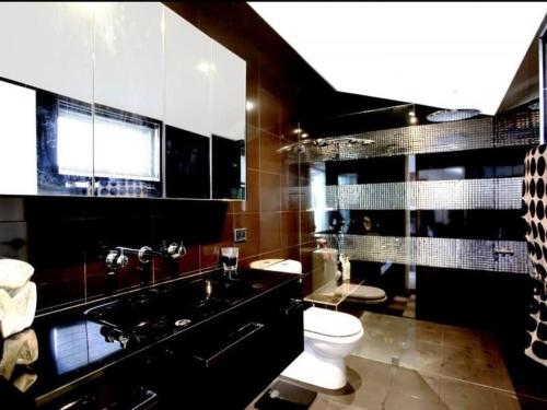 a bathroom with a black sink and a toilet at Modern spacious 3 bedroom penthouse in Enmore in Sydney