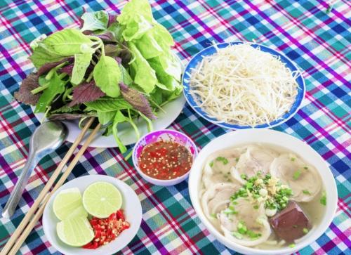 una mesa con platos de comida y una ensalada y tazones de sopa en Ty Phu Miet Vuon Homestay - Entire Bungalow, en Tây Ninh