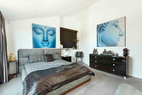 a bedroom with a large bed and a dresser at Modern spacious 3 bedroom penthouse in Enmore in Sydney