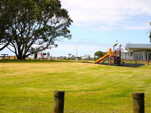 - une aire de jeux avec toboggan dans un parc dans l'établissement Seasong - Waihi Beach Holiday Home, à Waihi Beach