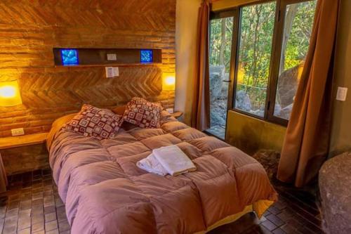 1 dormitorio con 1 cama grande en una cabaña de madera en Casa Loft en San Javier
