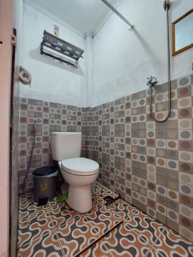 y baño con aseo y ducha. en Maharani Homestay, en Gorontalo