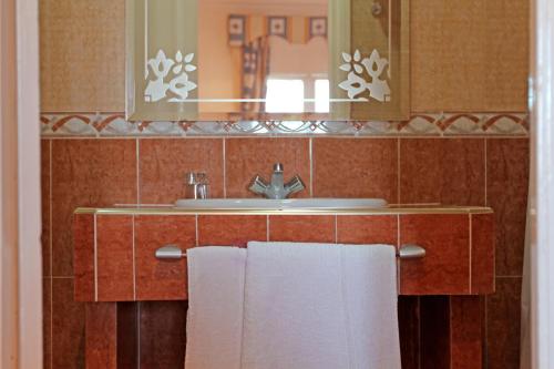 ein Badezimmer mit einem Waschbecken, einem Spiegel und Handtüchern in der Unterkunft Hotel Continental in Tangier