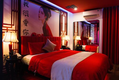 um quarto com uma cama vermelha e uma grande pintura na parede em Chiic House 2 - Khách sạn tình yêu em Da Nang