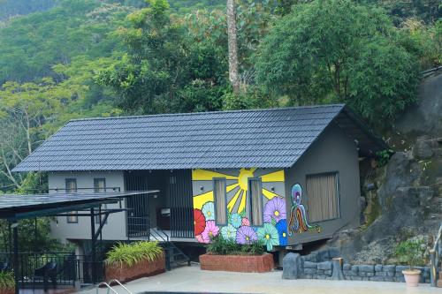 a building with a painting on the side of it at Konfudha Resort in Kalpetta