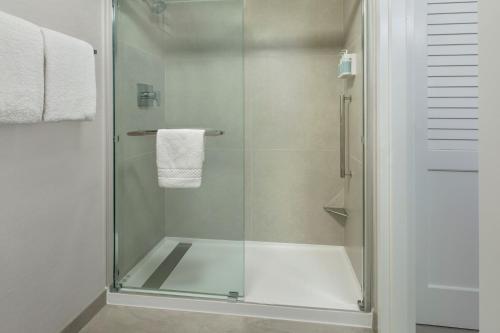 y baño con ducha y puerta de cristal. en Courtyard by Marriott Tarrytown Westchester County en Tarrytown