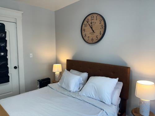 reloj en la pared sobre una cama con almohadas en Perfect stay for couples en Springfield