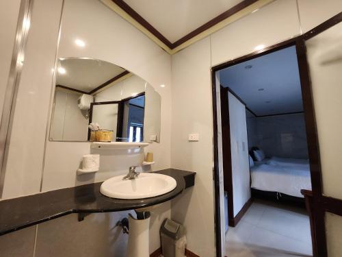 a bathroom with a sink and a mirror and a bed at TUAN Central Hotel in Hanoi