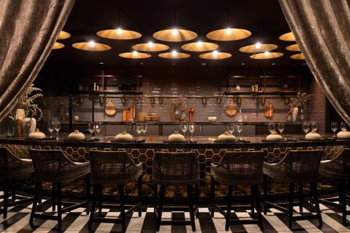 a bar at a restaurant with chairs and lights at JW Marriott Los Angeles L.A. LIVE in Los Angeles