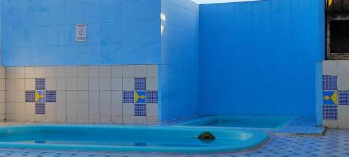 a blue tub in the corner of a bathroom at Onde a vida acontece in Salvador