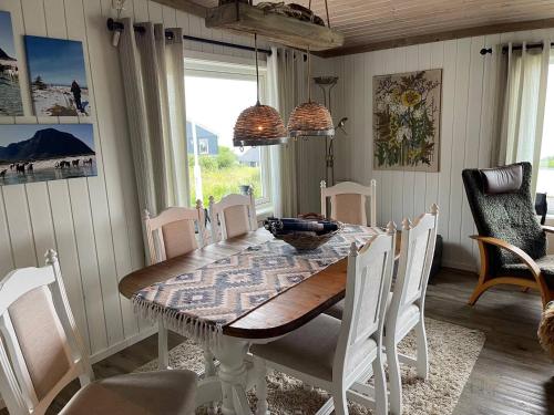 a dining room with a wooden table and chairs at Paradis i Brenna, Lofoten in Kleppstad
