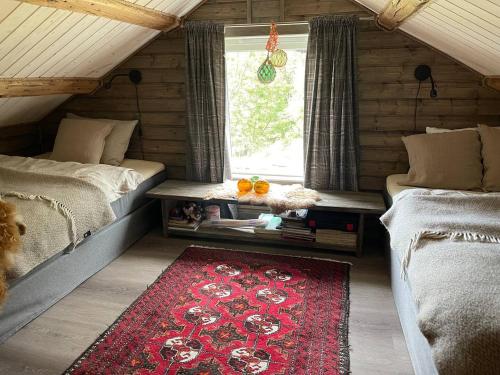 1 dormitorio con 2 camas y alfombra roja en Paradis i Brenna, Lofoten, en Kleppstad