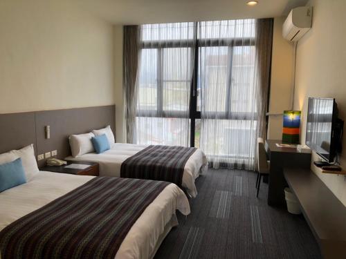 a hotel room with two beds and a television at Ita taiwan indigenous cultural resort in Taitung City