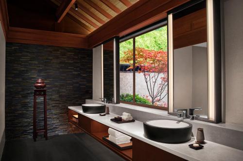 baño con 2 lavabos y ventana grande en Rissai Valley, a Ritz-Carlton Reserve, en Jiuzhaigou