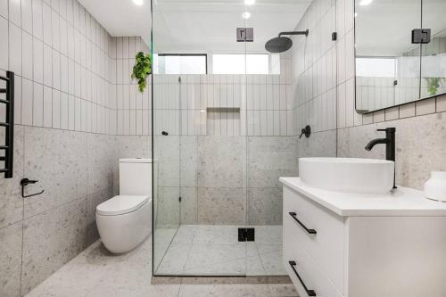 a bathroom with a shower and a toilet and a sink at Stylish 2- Bedroom Unit near parks, shopping and dining in Melbourne