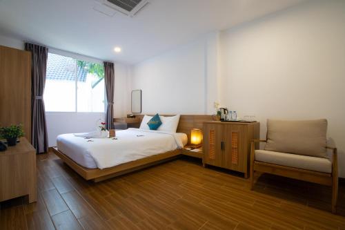 Palace Long Hai Resort & Spa في لونغ هاي: غرفة نوم بسرير وكرسي ونافذة