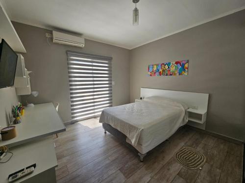 - une chambre avec un lit, un bureau et une fenêtre dans l'établissement Casa hermosa,comoda, luminosa, à Presidencia Roque Sáenz Peña