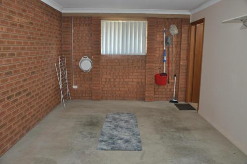 a room with a brick wall and a rug at Blue Wren Cottage in Tumut