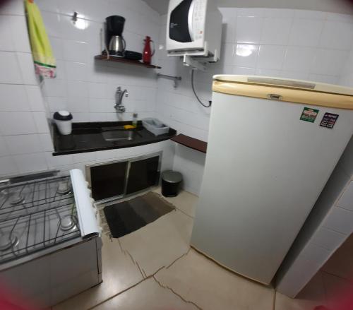 a small kitchen with a sink and a refrigerator at Iguabinha Duplex Pé na Areia in Iguaba Grande